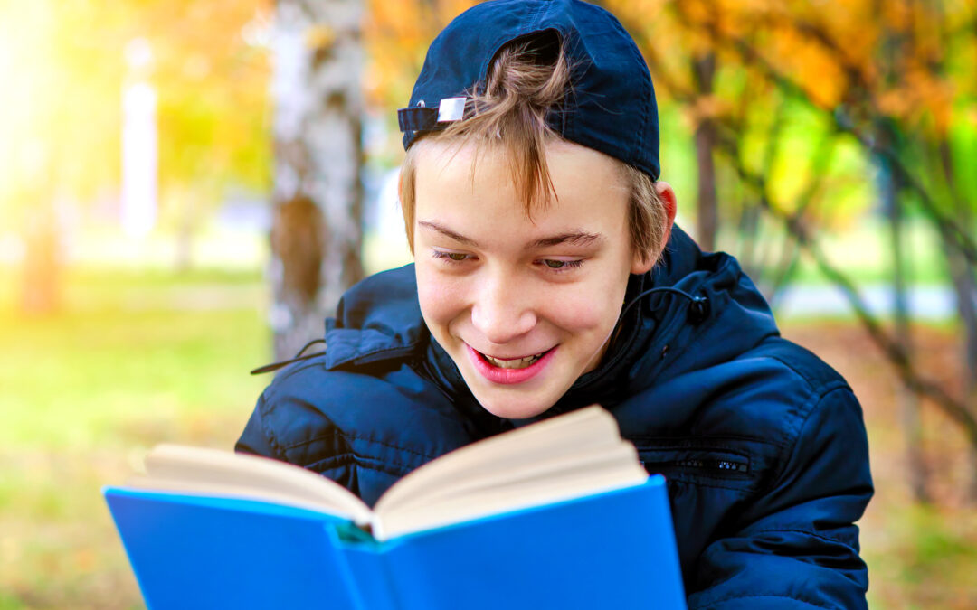 teen boy reading outside