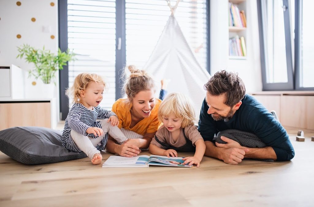 young family enjoying reading together in living room