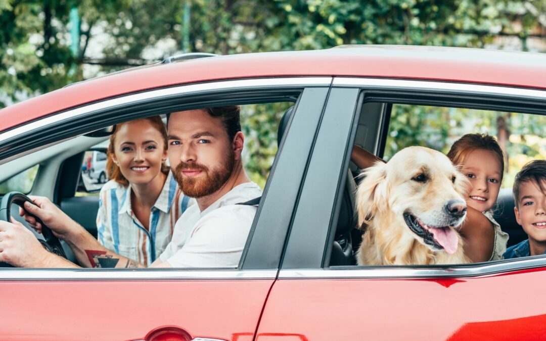 happy family in car with dog listening to audiobook