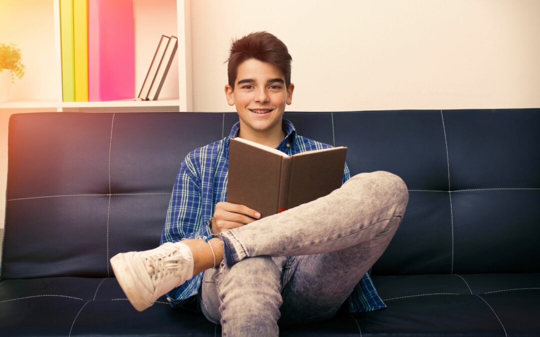 teen boy reading on couch