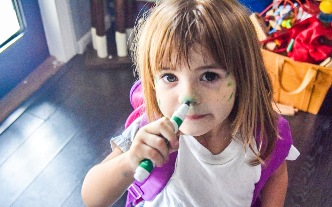 two year old girl with marker coloring her face