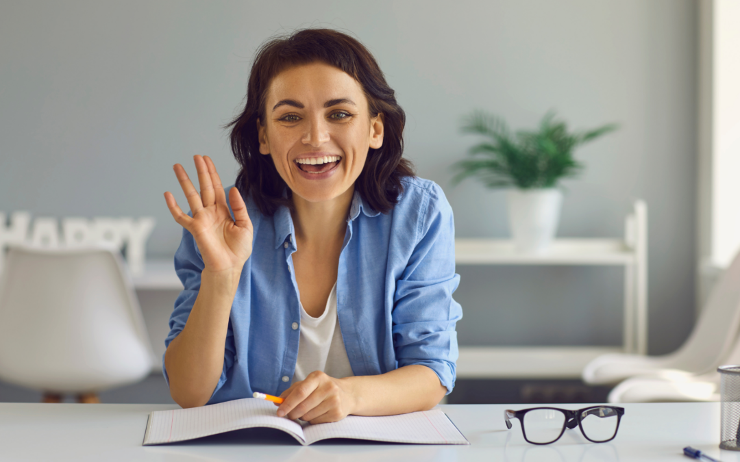 Catholic homeschool mom with a book, waving and smiling