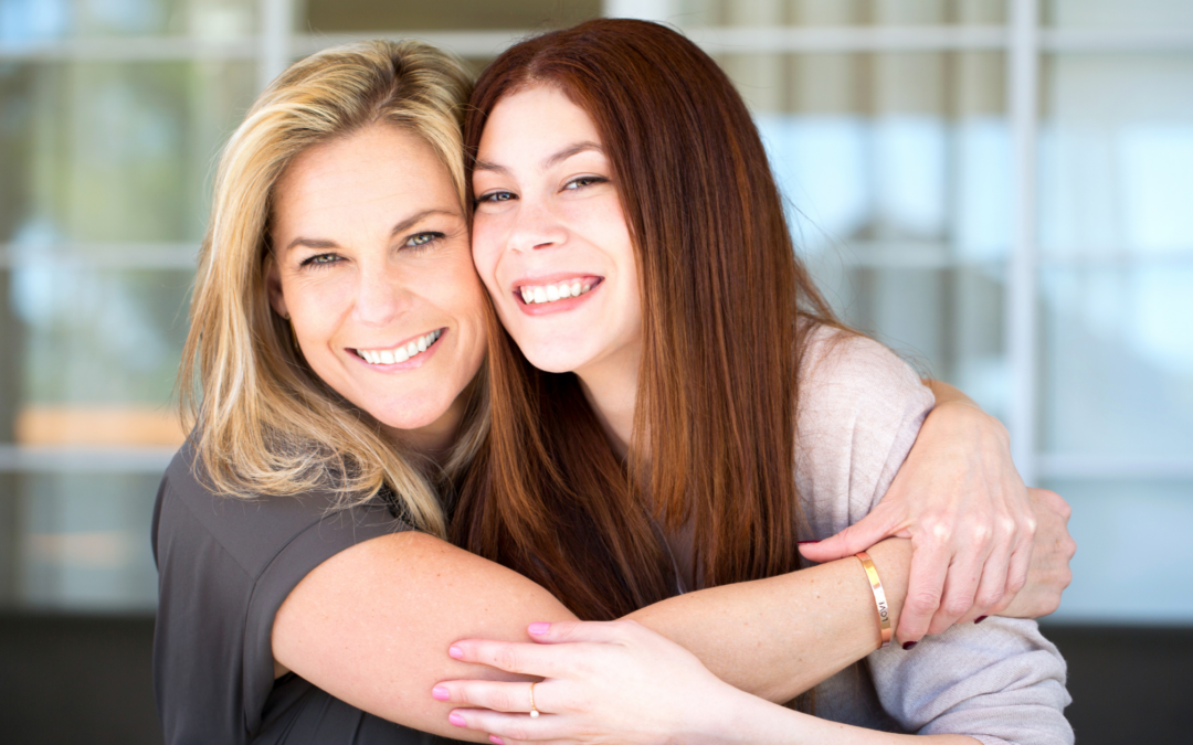 catholic homeschool mom and teen daughter smiling and hugging
